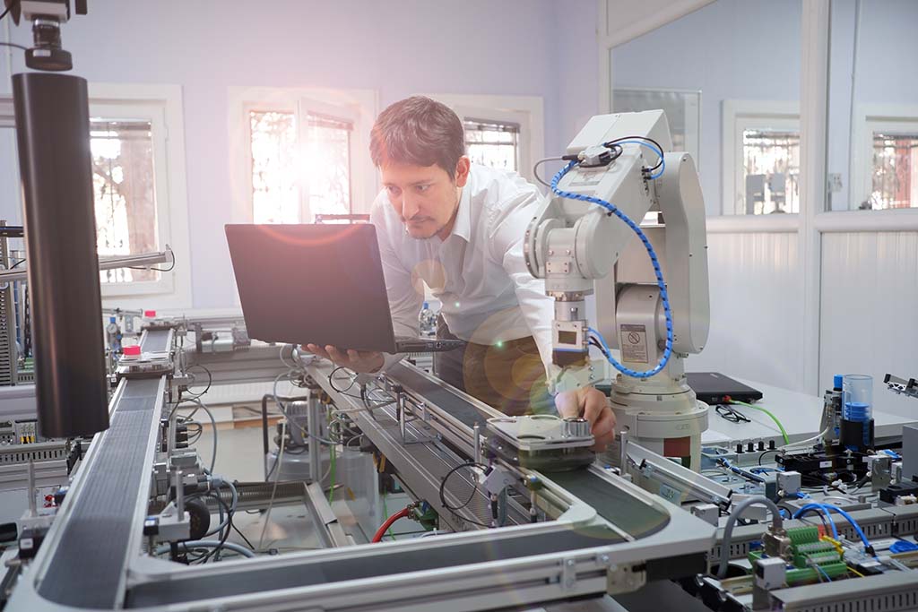 An engineer checking their laptop in a smart factory